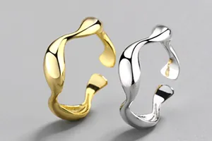 Detailansicht von zwei unregelmäßigen Wellenringen in poliertem Gold- und Silberfinish