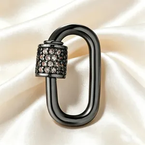 Detailed close-up of glossy black oval screw clasp pendant with pink zircon stones on satin