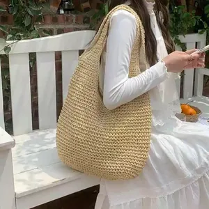 Große geflochtene Strohtasche für den Strandurlaub am Meer, getragen von einem Model