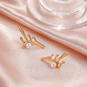Niche irregular gold lava stud earrings with pearl accents on pink satin fabric background