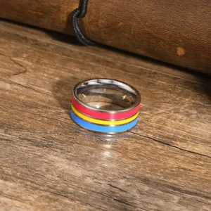 Detail shot of a stainless steel ring with vibrant red yellow blue enamel stripes