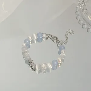 Detailed view of an elegant blue and white beaded bracelet with silver star charms on mirror