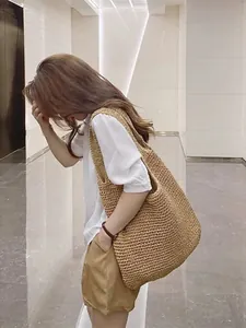 Große geflochtene Stroh-Einkaufstasche an einem asiatischen Model im Sommeroutfit.