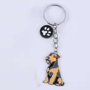 Detailansicht eines Metall-Emaille-Schlüsselanhängers mit Airedale-Terrier-Hund und Pfotenanhänger