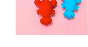 Detail view of cute red and blue cartoon lobster keychains on a soft pink background