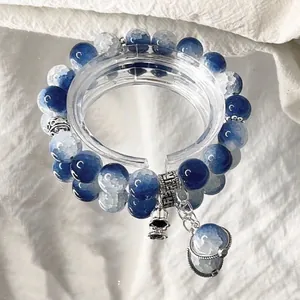 Detail of blue and white gradient beaded bracelet featuring unique silver robot charm