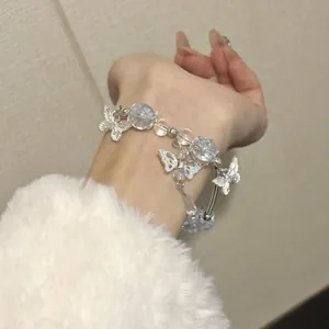 Detailed view of an elegant butterfly and crystal bead DIY bracelet worn on a wrist