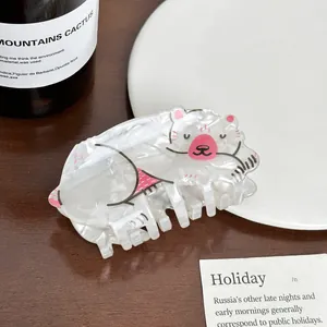 Close-up of white acrylic hair claw clip featuring a cute cartoon polar bear design