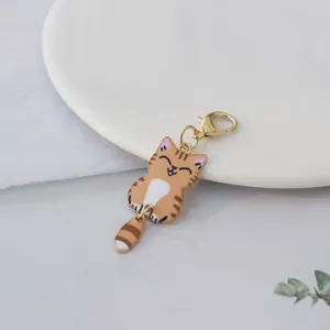 Detail showing a cute cartoon orange cat pendant with a swinging tail and gold clasp
