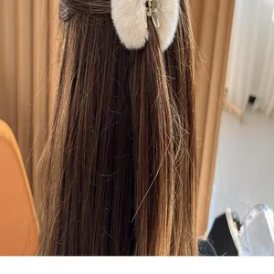 Macro view of a white rabbit fur hair claw clip accenting long straight brown hair