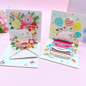Detailed view of two 3D pop-up greeting cards with flower and typewriter designs