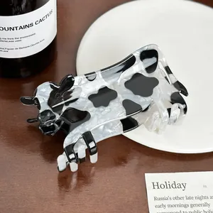 Cute acrylic cow-shaped hair claw clip with black and white animal print pattern design
