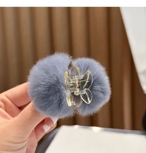 Detailed macro view of a cute mini hair claw clip with soft grey rabbit fur pom-poms