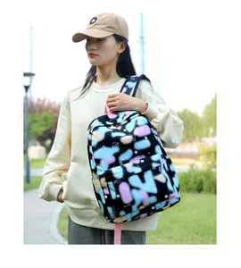 Asian model wearing a stylish colorful cow print backpack in an outdoor park setting