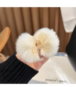 Close-up view of a soft white furry hair claw clip highlighting its plush texture