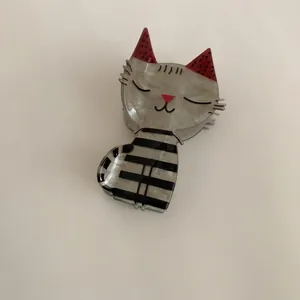 Detailed view of a cute marbled cat-shaped hair claw clip with red ears and stripes