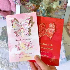 Close-up detail of 3D butterfly Valentine's Day greeting cards with romantic text.