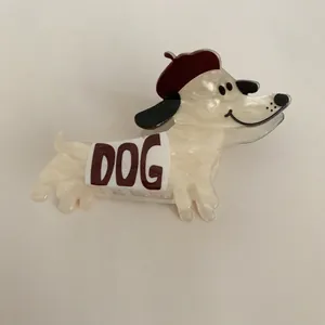 Close-up view of a cute dog-shaped acetate hair claw clip featuring a small red beret