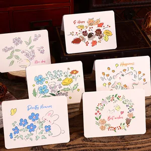 Close-up view of hand-drawn floral and animal themed greeting cards with warm messages