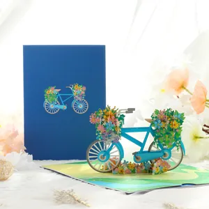 Blue 3D pop-up bicycle greeting card with vibrant floral baskets and envelope