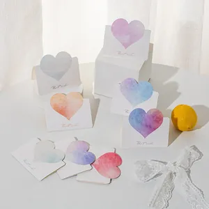Macro view of 3D leather heart greeting cards featuring colorful watercolor gradients.