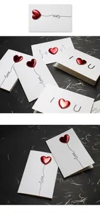 Close-up of greeting cards featuring 3D red leather hearts and love motif