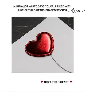 Detailed macro view of a 3D metallic red leather heart on a minimalist white card