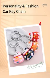 Detailed view showing four cute 3D cartoon lucky cat keychains in various bright colors