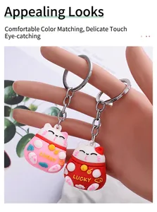 Detailed macro view of 3D cartoon lucky cat keychains in pink and red drip glue finish