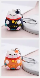 Detailed view of cute 3D lucky cat keychains in blue and orange, perfect for bag charms.