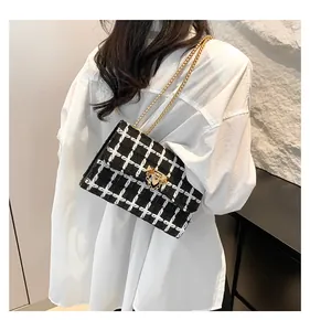 Stylish black and white plaid chain shoulder bag for women featuring gold-tone hardware
