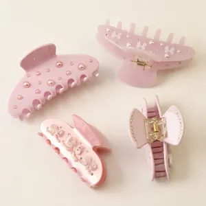 Set of elegant pink acetate hair claw clips decorated with faux pearls and rhinestones
