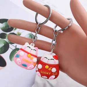 Cute 3D Maneki-neko lucky cat keychains in pink and red with engraved LUCKY lettering