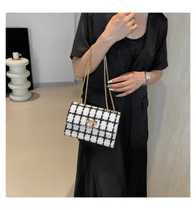 Close-up of a stylish black and white checkered chain shoulder bag for daily commuting