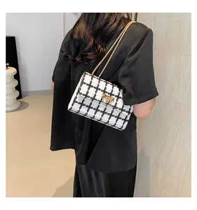 Detailed back view of model wearing a chic black and white checkered tweed chain bag