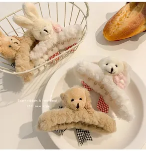 Detailed macro view of plush teddy bear and rabbit hair claws featuring cute ribbon accents