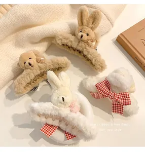 Close-up of plush bear and rabbit hair claw clips with checkered bows.