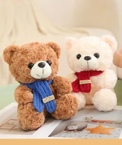 Dettaglio di una coppia di orsetti di peluche marroni e crema con sciarpe colorate