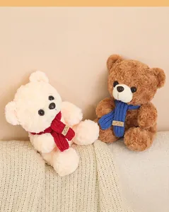 Coppia di simpatici orsetti di peluche con sciarpe rosse e blu su una morbida coperta.