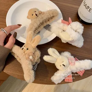 Detailed view of plush teddy bear and bunny hair claw clips with ribbon accents