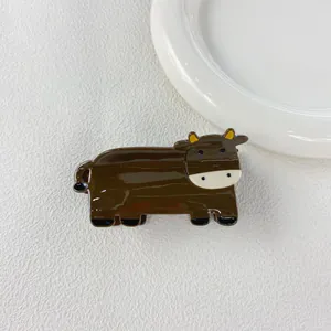 Close-up of a brown cartoon cow hair claw clip made of smooth acetate material