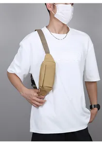 Détail d'un homme portant un sac de poitrine tactique kaki pour le sport et la course.
