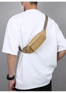 Vue arrière d'un sac banane tactique kaki porté par un modèle en t-shirt blanc