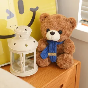 Adorabile orsacchiotto di peluche marrone con una calda sciarpa blu lavorata a maglia