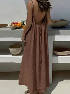 Rückansicht von lockeren braunen rückenfreien Damen-Trägerkleid am Mittelmeer