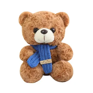 Morbido orsacchiotto di peluche marrone con sciarpa blu in maglia, regalo perfetto