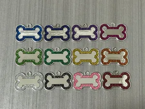 Detailed display of 12 glitter bone-shaped pet ID tags in various vibrant colors for dogs