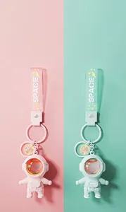 Detail view of pink and mint green astronaut keychains with sunset lamp visors.