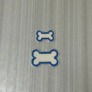 Detailed view of blue glitter bone-shaped pet ID tags in two sizes for collars