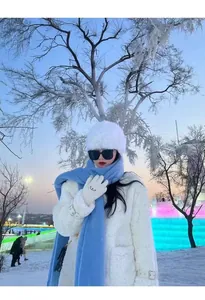 Soft light blue winter scarf for women worn on model in a beautiful snowy outdoor scene